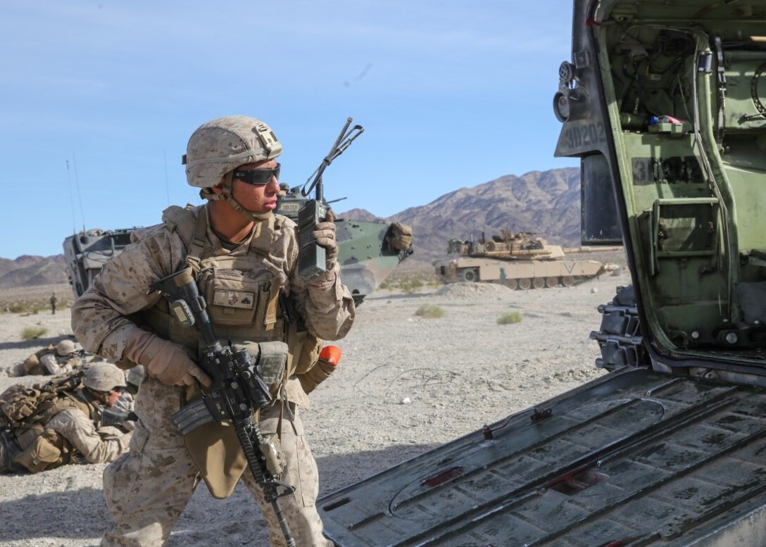 Cpl. Dustin Deloris relays orders over the radio during the mechanized assault portion of the Marine Corps Combat Readiness Evaluation at Marine Corps Air Ground Combat Center Twentynine Palms, Calif., Dec. 8, 2015. The purpose of a MCCRE is to evaluate Marines’ collective performance in specific mission requirements that will prepare them for their upcoming deployment rotation. Deloris is a team leader with Company E, 2nd Battalion, 7th Marine Regiment, 1st Marine Division. (U.S. Marine Corps photo by Lance Cpl. Devan K. Gowans)