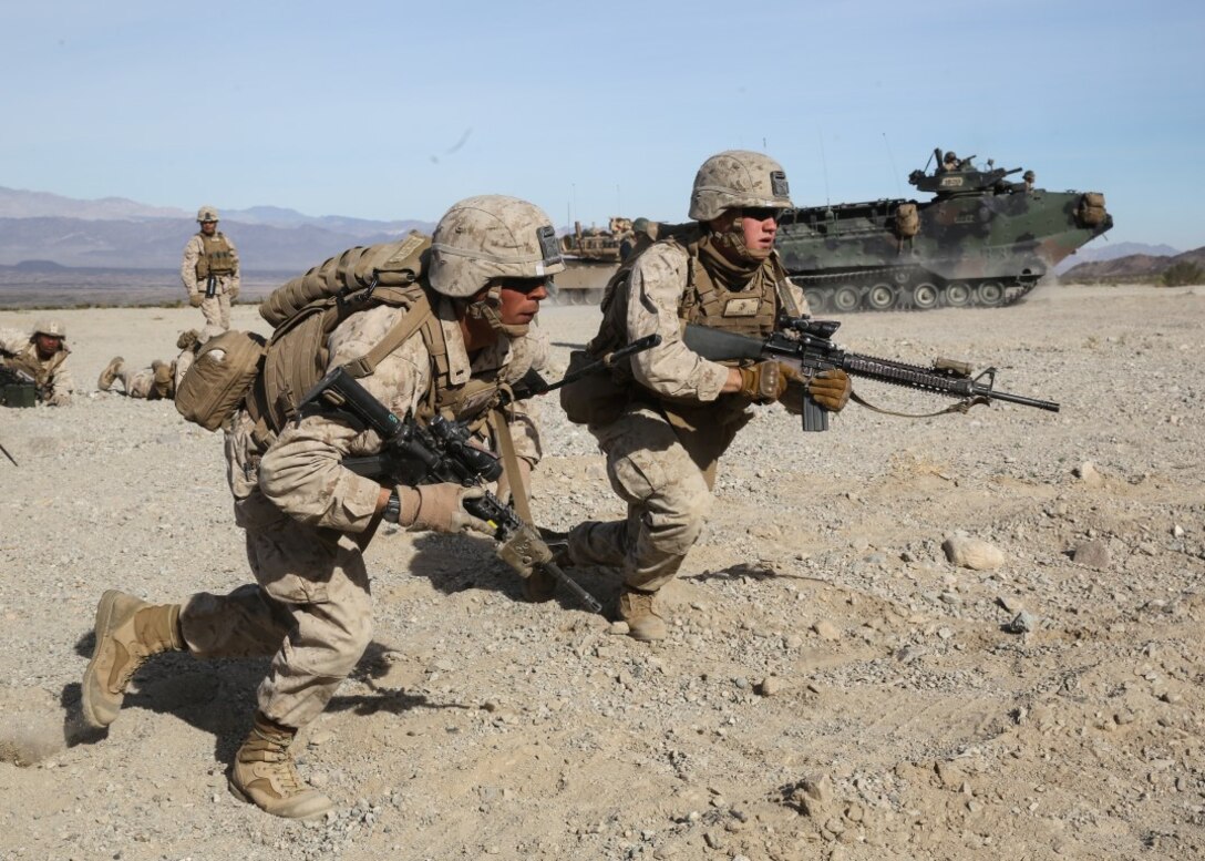 Marines rush a simulated combat town during the mechanized assault portion of a Marine Corps Combat Readiness Exercise at Marine Corps Air Ground Combat Center Twentynine Palms, Calif., Dec. 9, 2015. The purpose of a MCCRE is to evaluate Marines’ collective performance in specific mission requirements  that will prepare them for their upcoming deployment rotation. The Marines are with 2nd Battalion, 7th Marine Regiment, 1st Marine Division. (U.S. Marine Corps photo by Lance Cpl. Devan K. Gowans)