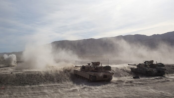 M1A1 Abrams tanks fire on targets during the mechanized assault portion of a Marine Corps Combat Readiness Evaluation at Marine Corps Air Ground Combat Center Twentynine Palms, Calif., Dec. 8, 2015. The purpose of a MCCRE is to evaluate Marines’ collective performance in specific mission requirements that will prepare them for their upcoming deployment rotation. The tanks are supporting 2nd Battalion, 7th Marine Regiment, 1st Marine Division. (U.S. Marine Corps photo by Lance Cpl. Devan K. Gowans)