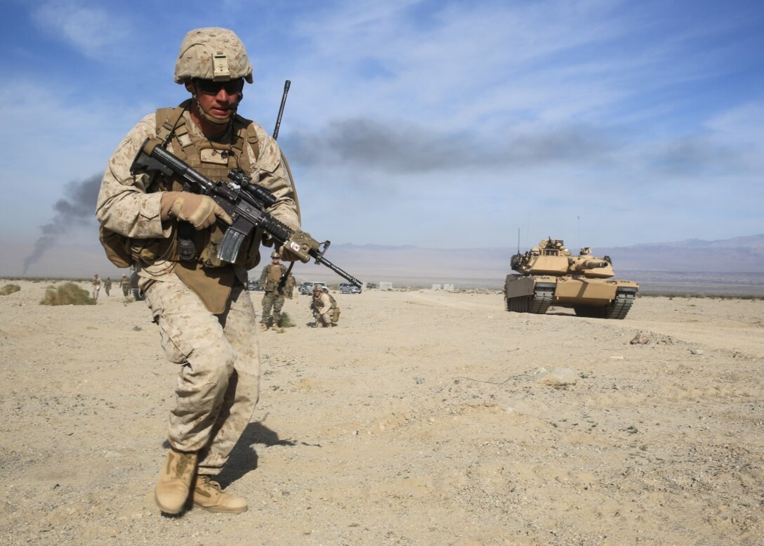 Staff Sgt. Anthony L. Abitz charges toward a mock combat town during the mechanized assault portion of a Marine Corps Combat Readiness Evaluation at Marine Corps Air Ground Combat Center Twentynine Palms, Calif., Dec. 10, 2015. The purpose of a MCCRE is to evaluate Marines’ collective performance in requisite specific mission requirements that will prepare them for their upcoming deployment rotations. Staff Sgt. Abitz is a machine gunner with 2nd Battalion, 7th Marine Regiment, 1st Marine Division. (U.S. Marine Corps photo by Lance Cpl. Devan K. Gowans)