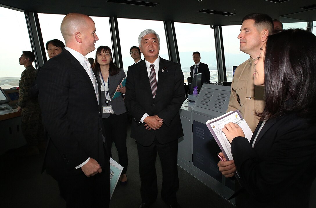 From left to right. Brian Wottowa, director of Iwakuni's Integrated Program Management Office for the Defense Policy Review Initiative, speaks to Gen Nakatani, Japanese Defense Minister, Col. Robert V. Boucher, commanding officer of Marine Corps Air Station Iwakuni, Japan, and Yoko Seo, technical information specialist with protocol at Headquarters and Headquarters Squadron, during a station visit to the air traffic control tower, Dec. 2, 2015. Nakatani met with station officials and toured Marine Aerial Refueler Transport Squadron 152 (VMGR-152) facilities to obtain a better look at the station’s capabilities.