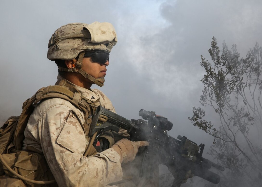 A Marine conceals himself under the obstruction of deployed smoke during the company supported, live-fire assault portion of a Marine Corps Combat Readiness Evaluation at Marine Corps Air Ground Combat Center Twentynine Palms, Calif., Dec. 6, 2015. The purpose of a MCCRE is to evaluate Marines’ collective performance in specific mission requirements that will prepare them for their upcoming deployment rotation. The Marine is with 2nd Battalion, 7th Marine Regiment, 1st Marine Division. (U.S. Marine Corps photo by Lance Cpl. Devan K. Gowans)