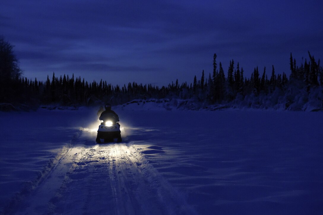 Marine Corps Sgt. Mauricio Sandoval travels via snow mobile to deliver gifts for Toys for Tots in Nikolai, Alaska, Dec. 10, 2015. Sandoval is assigned to Delta Company, 4th Law Enforcement Battalion. U.S. Air Force photo by Alejandro Pena