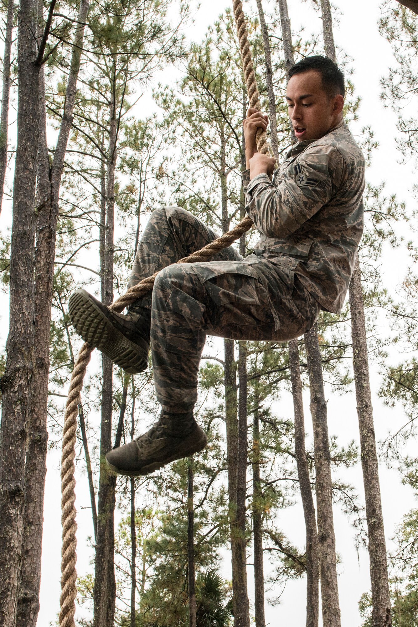 U.S. Air Force Airman 1st Class Cristian Ring, 820th Base Defense Group fireteam member, climbs a rope as part of an obstacle course during an air assault assessment, Dec. 15, 2015, at Camp Blanding, Fla. Airmen had two attempts to climb the rope and pull themselves onto the tower in order to pass the obstacle course. (U.S. Air Force photo by Airman 1st Class Lauren M. Johnson/Released)