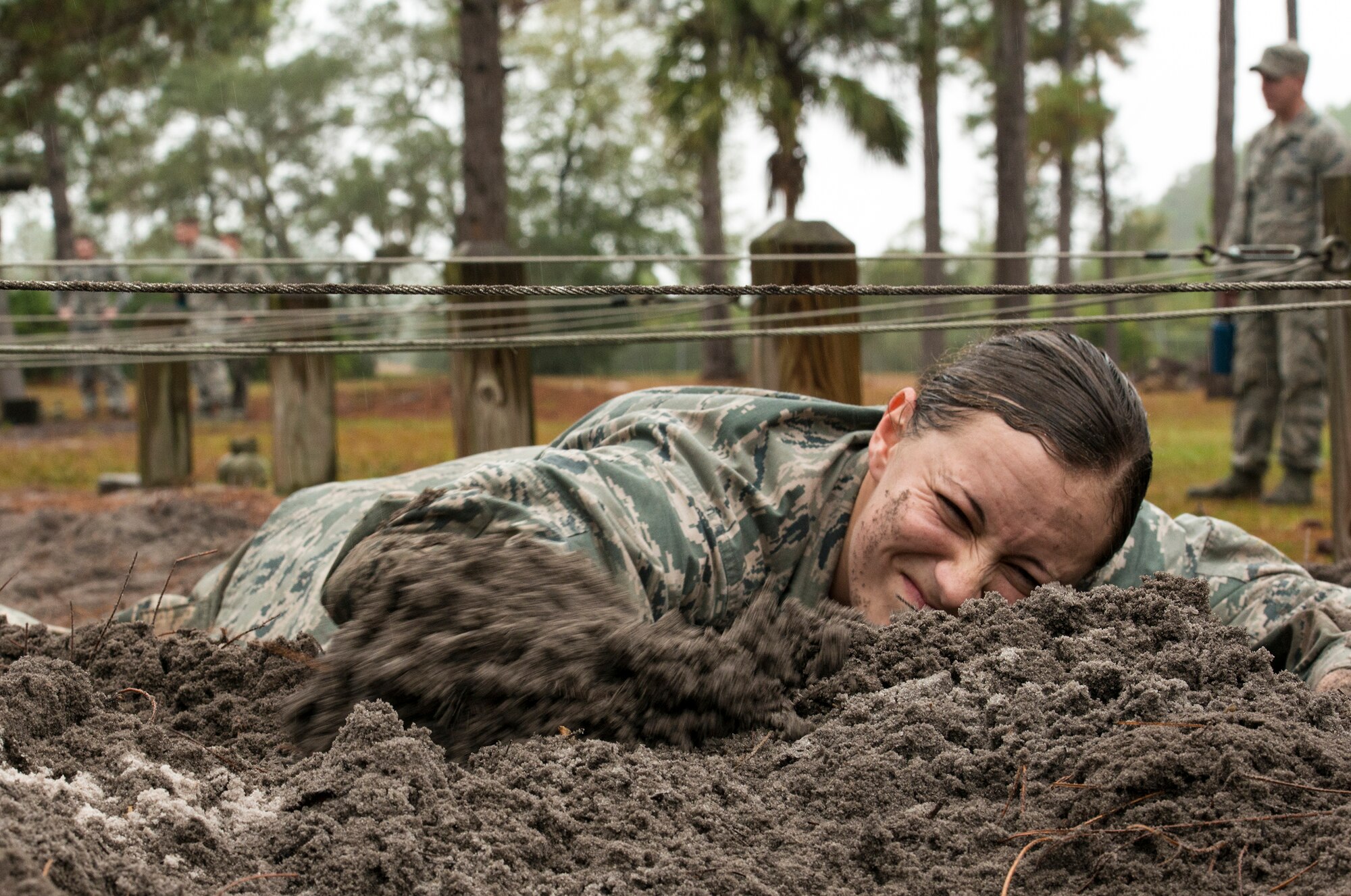 U.S. Air Force 2nd Lt. Lizette Wu, 820th Base Defense Group, low crawls through mud as part of an obstacle course during an air assault assessment, Dec. 15, 2015, at Camp Blanding, Fla. Airmen had to crawl through the mud without letting any part of their body touch the metal wires hung above. (U.S. Air Force photo by Airman 1st Class Lauren M. Johnson/Released)