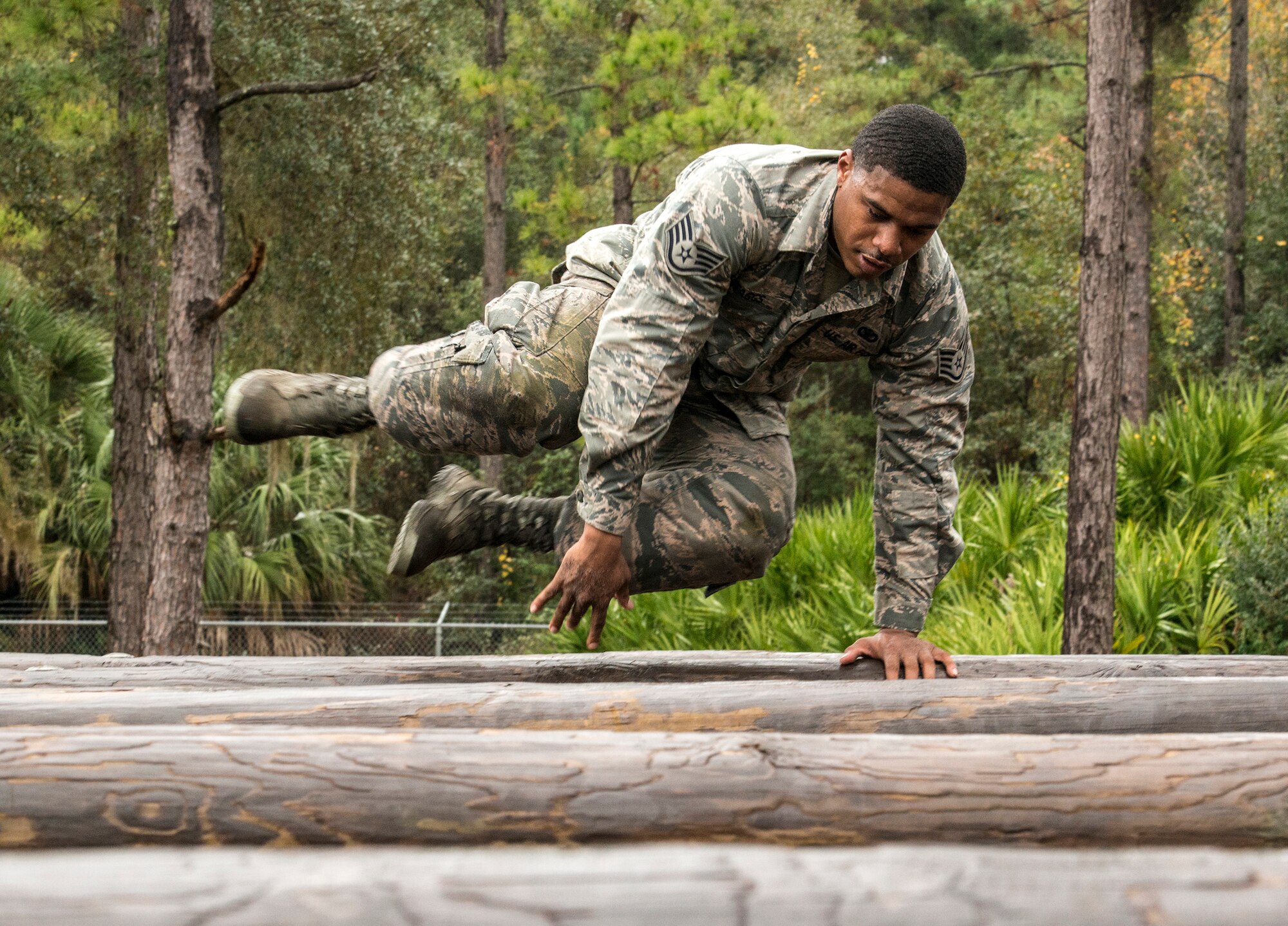 U.S. Air Force Staff Sgt. Dontavian Staggs, 820th Base Defense Group fireteam leader, jumps over an obstacle during an air assault assessment, Dec. 15, 2015, at Camp Blanding, Fla. During this exercise, Airmen had to jump over the 3-foot obstacle, letting only their hands touch the logs. (U.S. Air Force photo by Airman 1st Class Lauren M. Johnson/Released)
