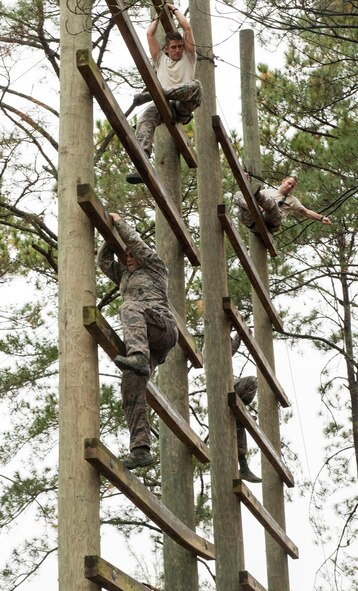 U.S. Air Force Senior Airman Max Biser, bottom left, 820th Base Defense Group fireteam member, climbs a tower as part of an obstacle course during an air assault assessment, Dec. 15, 2015, at Camp Blanding, Fla. The obstacle course was part of a voluntary, three-day assessment to qualify for Army Air Assault School attendance. (U.S. Air Force photo by Airman 1st Class Lauren M. Johnson/Released)


