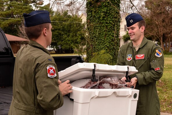 First Lts. Zach Horrocks (left) a weapon systems officer and Josh Eggleston, a pilot, both basic students from the 333rd Fighter Squadron carry approximately 65 pounds of venison meat, Dec. 21, 2015, at the Community Soup Kitchen of Goldsboro, North Carolina. The 22 Basic Course students assigned to class 15-DBE devoted a weekend to process and package three harvested deer to donate to the local soup kitchen. (U.S. Air Force photo/Senior Airman Aaron J. Jenne) 
