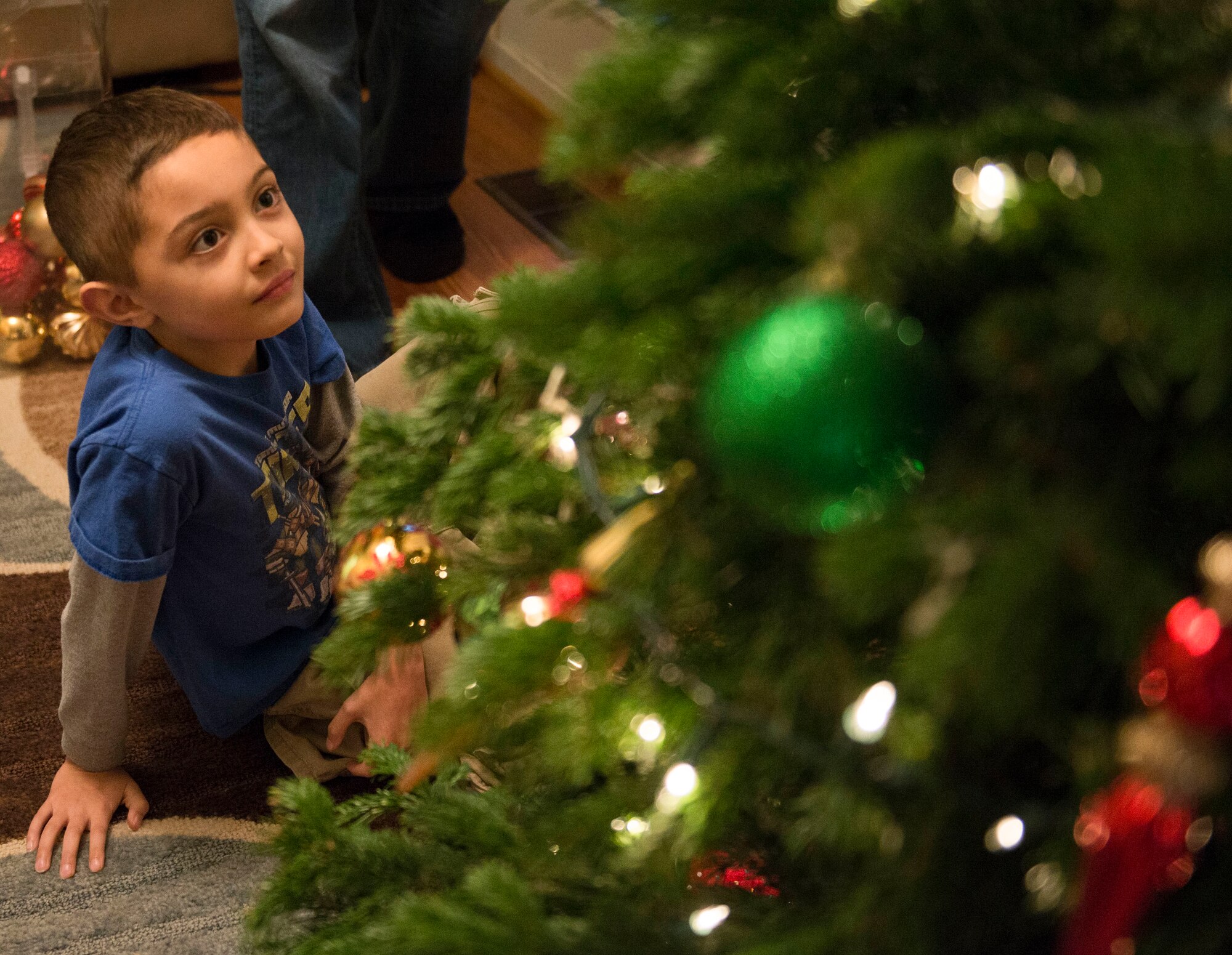 Timmy Payne admires his work on his family Christmas tree at his home in Mountain Home, Idaho, Dec. 5, 2015. At the young age of seven, Timmy has already experienced separation from both of his parents due to multiple deployments. (U.S. Air Force photo by Airman 1st Class Jessica H. Evans/RELEASED)