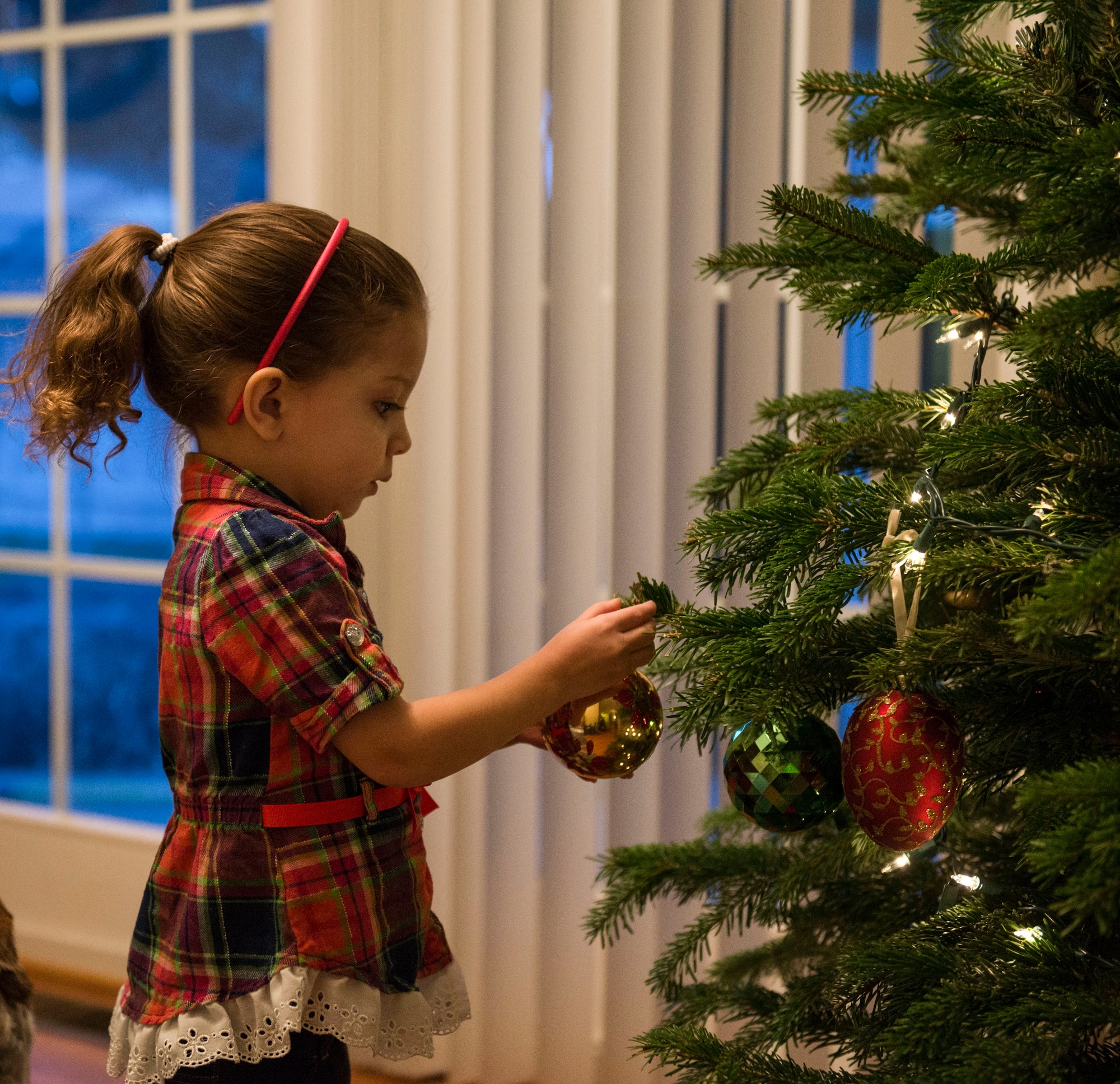 Yai Payne hangs an ornament on her family Christmas tree in Mountain Home, Idaho, Dec. 5, 2015. For Yai, this is the first time she has been separated from her mother due to a deployment. (U.S. Air Force photo by Airman 1st Class Jessica H. Evans/RELEASED)