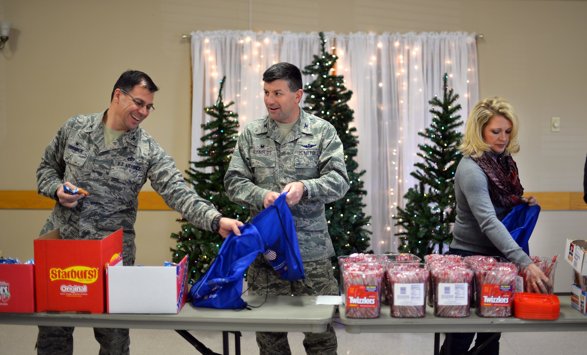 U.S. Air Force Col. Marty Reynolds, 55th Wing commander, his wife, Deanna, and U.S. Air Force Col. Matthew Joganich, 55th Mission Support Group commander, fill gift bags that will be donated to Airmen living in the Offutt Air Force Base, Neb., dormitories this holiday season at the Bellevue Fire House on Dec. 17, Bellevue, Neb.  Local area businesses show their support by donating to the gift bags as well as volunteering to fill and distribute them.  (U.S. Air Force photo by Josh Plueger)