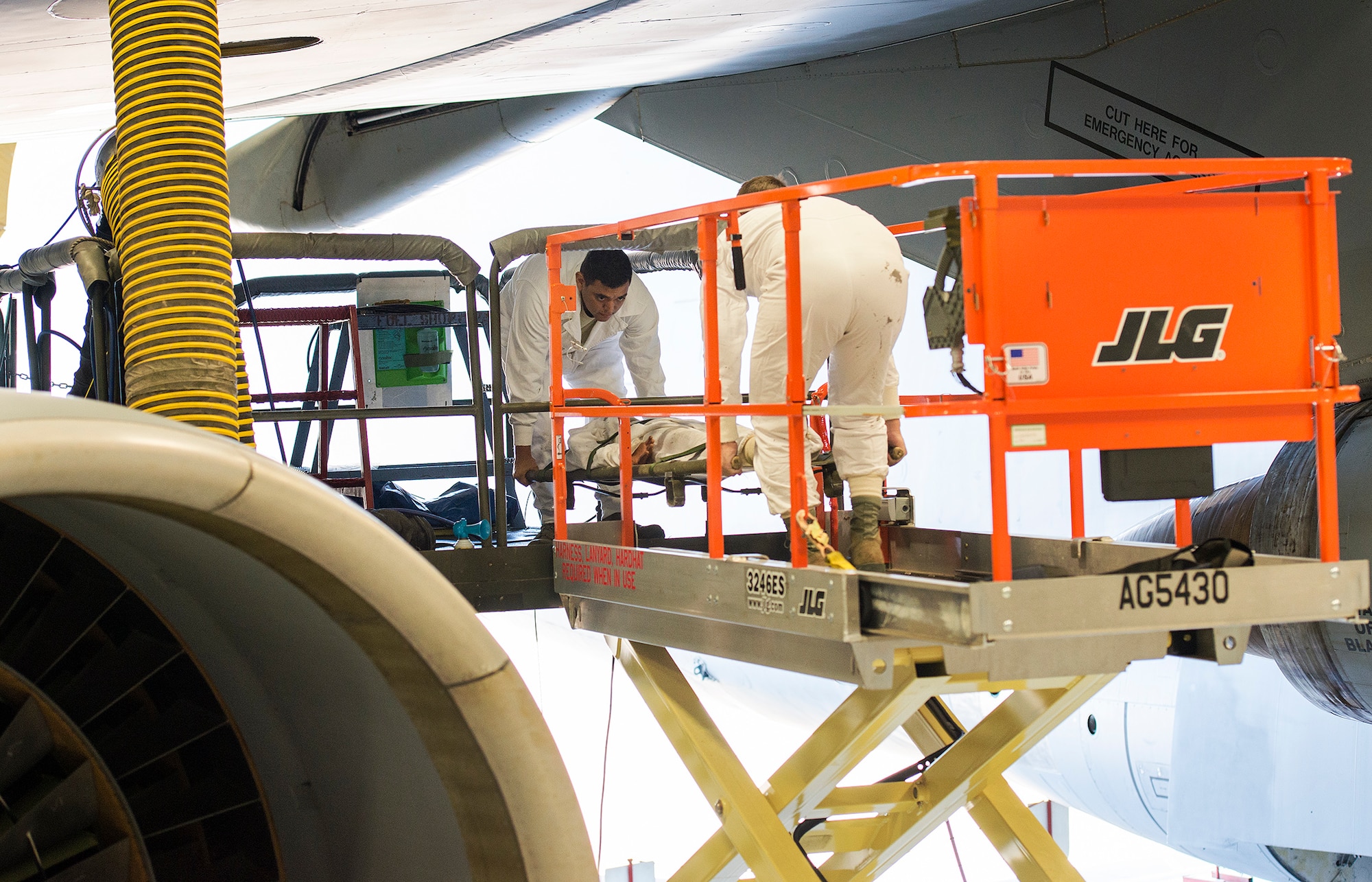 Senior Airmen Eric Garcia and Joseph Hargrave, 433rd Maintenance Squadron aircraft fuel systems technicians, secure the manikin to a gurney before transporting them to the hydraulic scissor lift Dec. 17, 2015 at Joint Base San Antonio-Lackland, Texas. The annual exercise is graded for extraction protocol, execution time, and safety. This year the Airmen completed the exercise in record time, 3 minutes and 15 seconds. (U.S. Air Force photo by Benjamin Faske) (released)