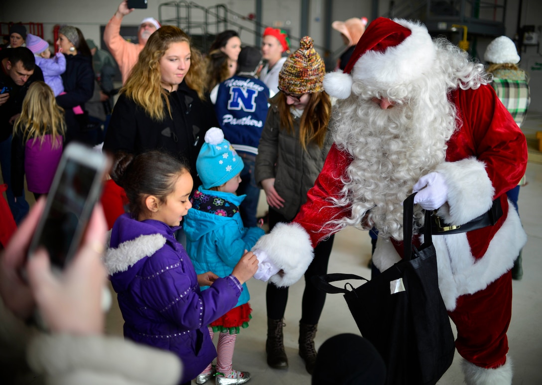 More than 100 families and their children were treated to a visit by Santa here on Dec. 19, 2015. This event, which was open to base personnel, retirees and their families included a special entrance by Santa.  Visitors lined the entrance of Hangar 707 eagerly awaiting Santa, who arrived on a C-130 Hercules. (U.S. Air Force photo by Tech. Sgt. Stephanie Sawyer)
