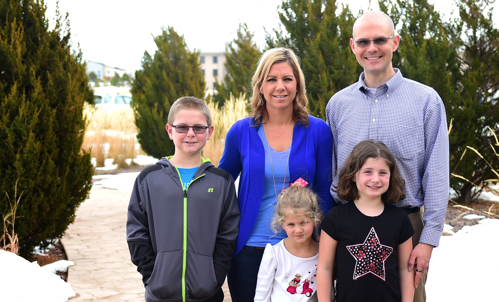 Maj. Jim Bridgham, 140th Wing chaplain, poses with his family outside the Buckley Chapel Dec. 20, 2015, on Buckley Air Force Base, Colo. As a father of three, husband and now a Colorado Air Guard chaplain, Bridgham juggles a lot of tasks, such as activities for his kids and helping all branches of the military in not only work but also personal matters. (U.S. Air Force photo by Airman 1st Class Gabrielle Spradling/Released)