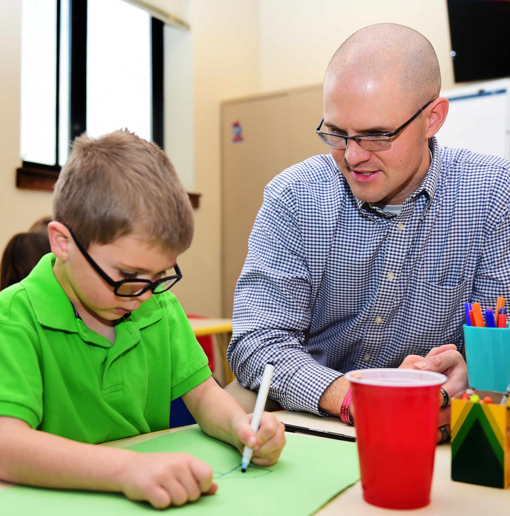 Maj. Jim Bridgham, 140th Wing chaplain, teaches a Team Buckley youth during Sunday school at the Buckley Chapel Dec. 20, 2015, on Buckley Air Force Base, Colo. Bridgham uses lessons learned from his life experience to help Buckley personnel through challenging times. (U.S. Air Force photo by Airman 1st Class Gabrielle Spradling/Released)