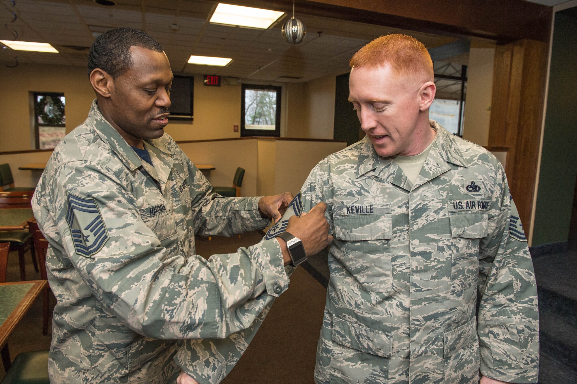 Chief Master Sgt. Omar Hardman, 66th Medical Squadron superintendent, places chief master sergeant stripes on Senior Master Sgt. Wesley Keville's arm during a recognition ceremony at the Minuteman Commons Dec. 18. Keville is the Battle Management Directorate superintendent. Also selected for promotion to chief master sergeant was Senior Master Sgt. Aaron Marley, Air Force Life Cycle Management Center Detachment 7 superintendent. (U.S. Air Force photo by Jerry Saslav)