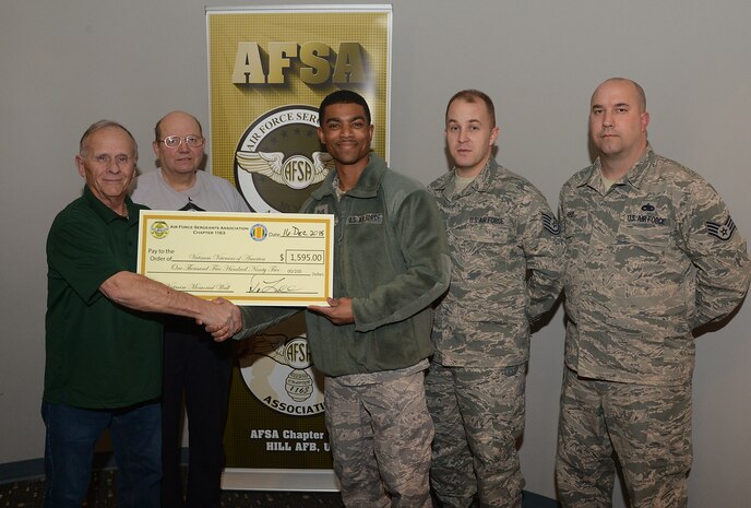 Air Force Sergeant's Association (AFSA) Chapter1163 members Tech. Sgt. Michael Corum, Tech. Sgt. Aaron Haviland and Staff Sgt. Jacob Reid present a check to Vietnam Veterans of America members Dennis Howland, far left, and David Wilson Dec. 16 at Hill Air Force Base, Utah. The AFSA chapter raised funds during POW/MIA Week by selling ribbons, bracelets and T-shirts along with sponsoring a 5K run in Layton, Utah. The base chapter chose the Vietnam Veterans of America as recipients of all the proceeds to help fund the Vietnam Memorial replica planned for Layton Commons Park. (U.S. Air Force photo/Alex R. Lloyd)