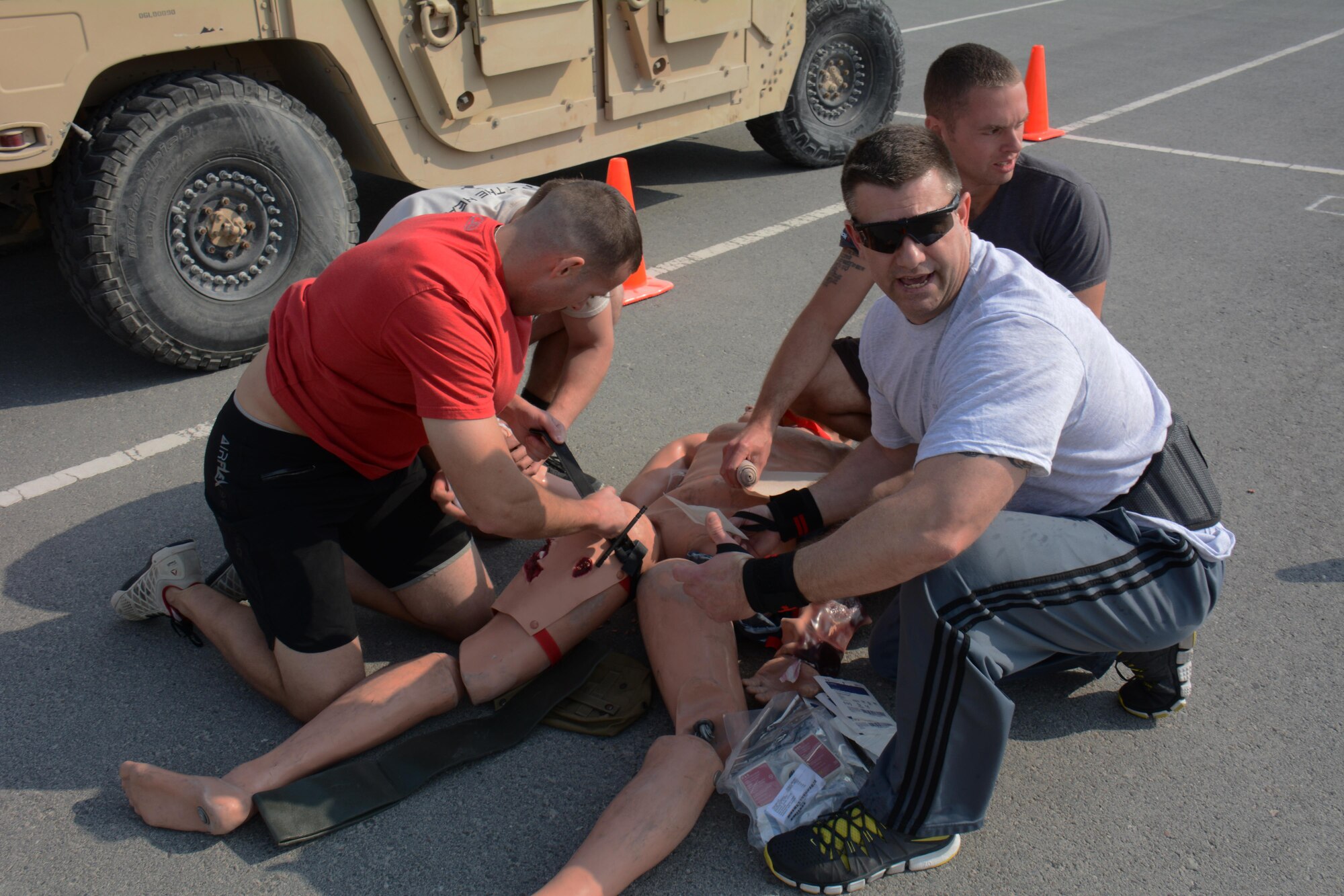 Deployed service members treat multiple wounds on a dummy during the annual Battle of the Badges competition at Al Udeid Air Base, Qatar Dec. 21. The competition consisted of numerous events over four days including firefighter, medical and security forces career field challenges, as well as a fitness challenge. During the fitness challenge teams of airmen had to put out a simulated fire, perform self-aid buddy care and push a Humvee more than 400 feet. The 379 ECES fire team took first place in the competition. (U.S. Air Force photo by Tech. Sgt. James Hodgman/Released) 
