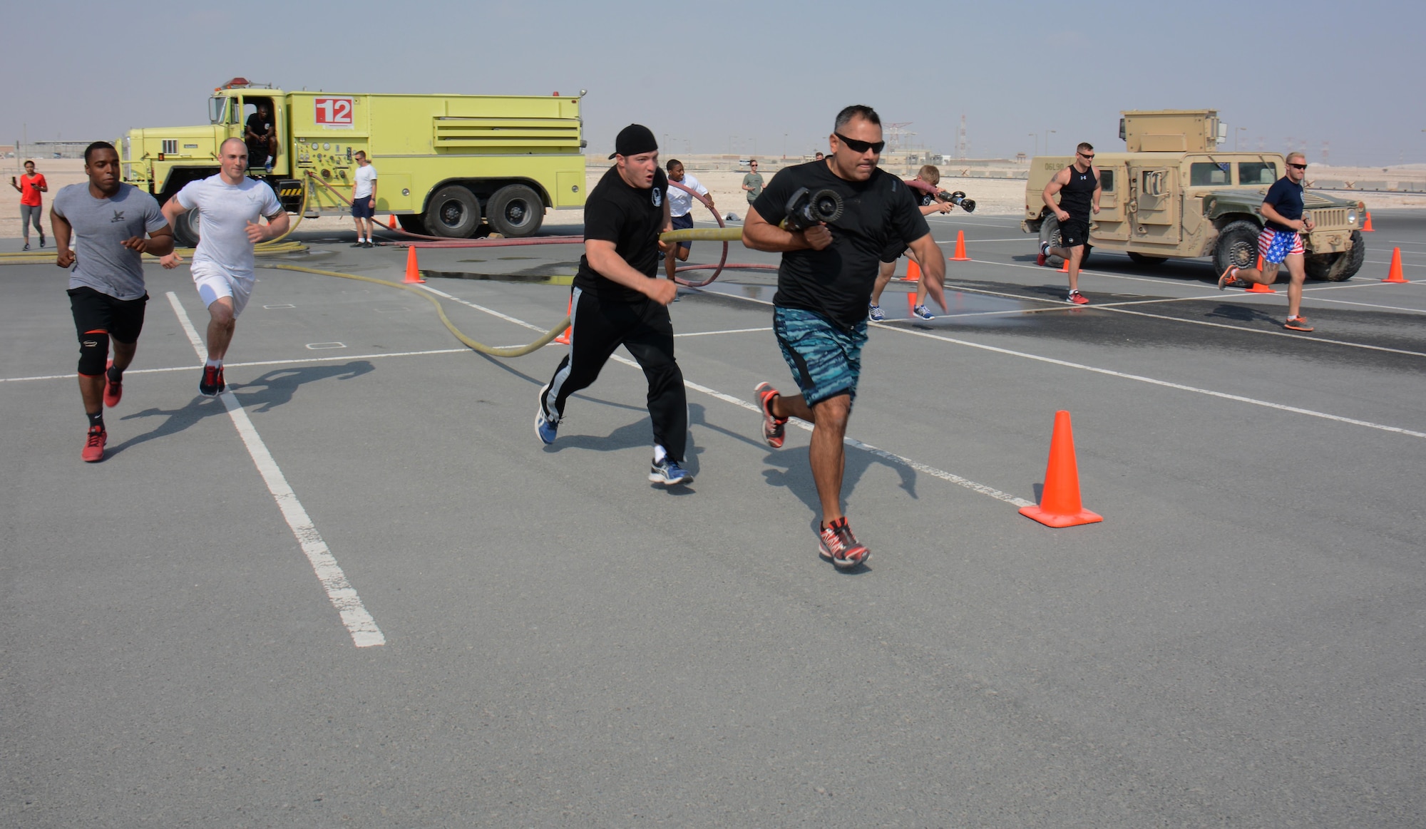 Deployed service members participate in the annual Battle of the Badges competition at Al Udeid Air Base, Qatar Dec. 21. The competition consisted of numerous events over four days including firefighter, medical and security forces career field challenges, as well as a fitness challenge. The 379th Expeditionary Civil Engineer Squadron fire team took first place in the competition. (U.S. Air Force photo by Tech. Sgt. James Hodgman/Released) 