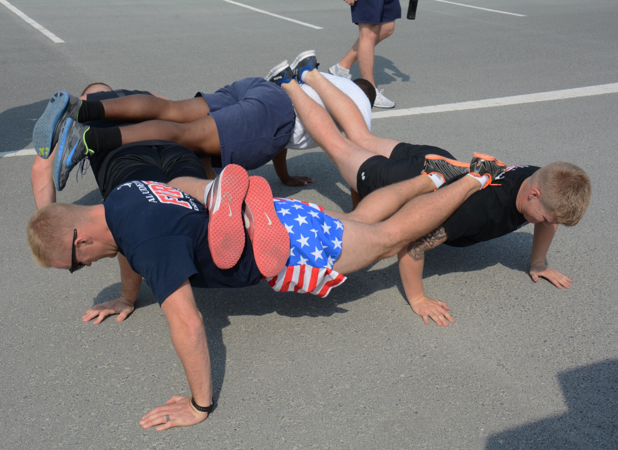 The 379th Expeditionary Civil Engineer Squadron fire team performs ranger push-ups during the annual Battle of the Badges competition at Al Udeid Air Base, Qatar Dec. 21. The competition consisted of numerous events over four days including firefighter, medical and security forces career field challenges, as well as a fitness challenge. The 379 ECES fire team took first place in the competition. (U.S. Air Force photo by Tech. Sgt. James Hodgman/Released) 