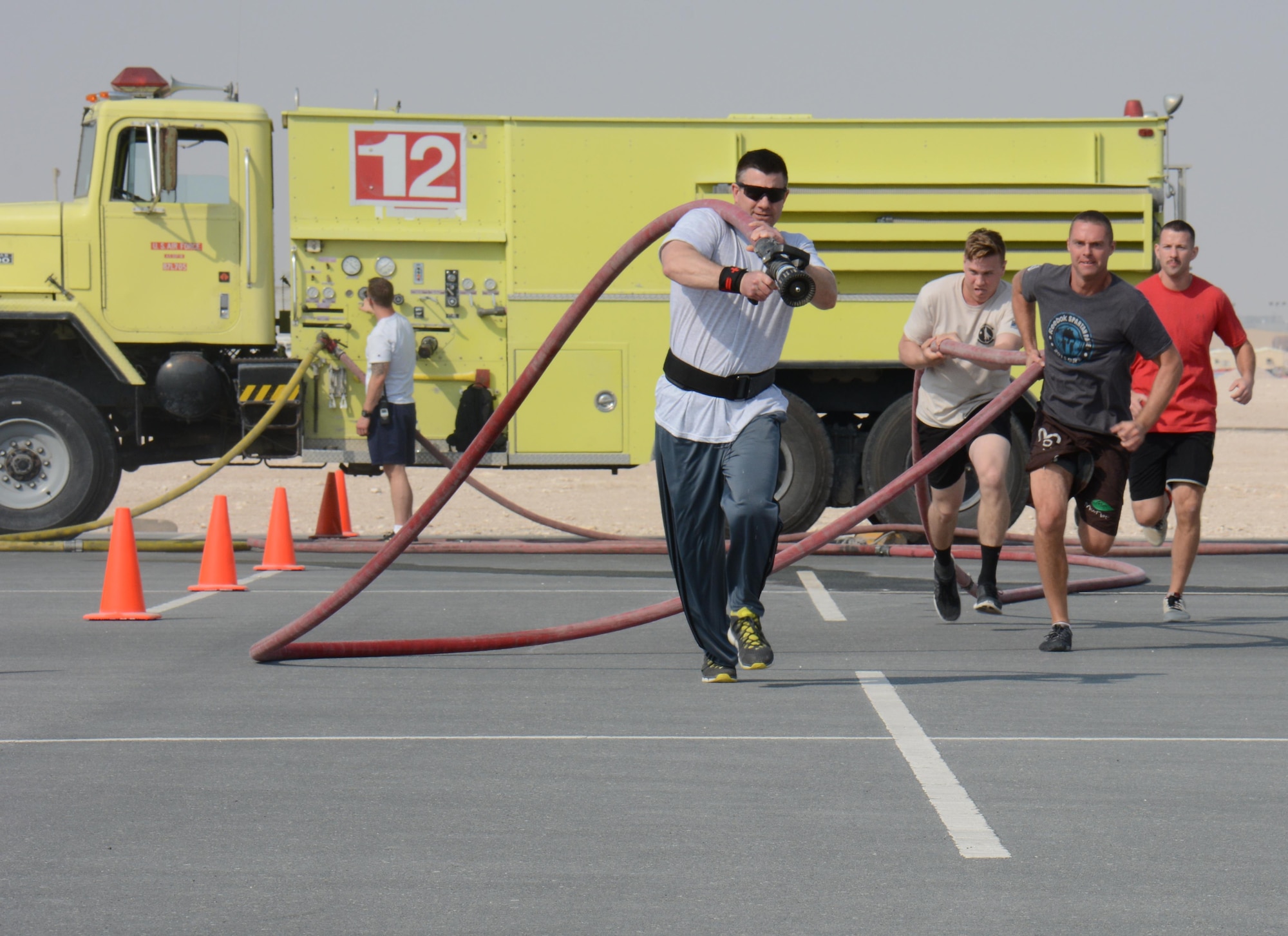 Deployed service members participate in the annual Battle of the Badges competition at Al Udeid Air Base, Qatar Dec. 21. The competition consisted of numerous events over four days including firefighter, medical and security forces career field challenges, as well as a fitness challenge. The 379th Expeditionary Civil Engineer Squadron fire team took first place in the competition. (U.S. Air Force photo by Tech. Sgt. James Hodgman/Released) 