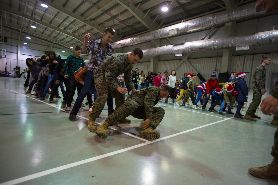 U.S. Marines, sailors, and soldiers play games at an early Christmas celebration with Romanian children on Mihail Kogalniceanu Air Base, Romania, Dec. 19, 2015. U.S. Marine Corps photo by Lance Cpl. Melanye E. Martinez