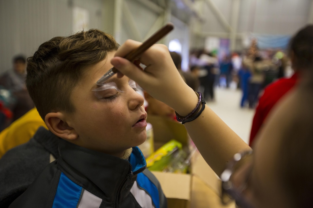 A Romanian boy gets his face painted at a Christmas celebration hosted by U.S. Marines, sailors and soldiers on Mihail Kogalniceanu Air Base, Romania, Dec. 19, 2015. U.S. Marine Corps photo by Lance Cpl. Melanye E. Martinez