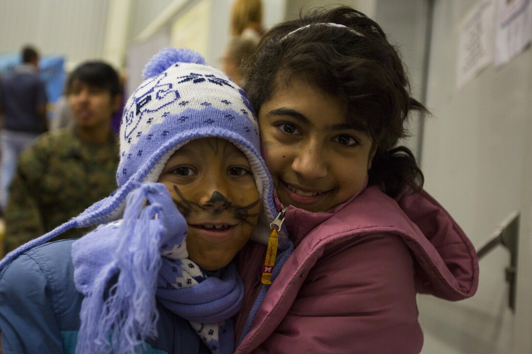 Romanian children smile for a photo during a Christmas party hosted by U.S. Marines, sailors and soldiers on Mihail Kogalniceanu Air Base, Romania, Dec. 19, 2015. U.S. Marine Corps photo by Lance Cpl. Melanye E. Martinez