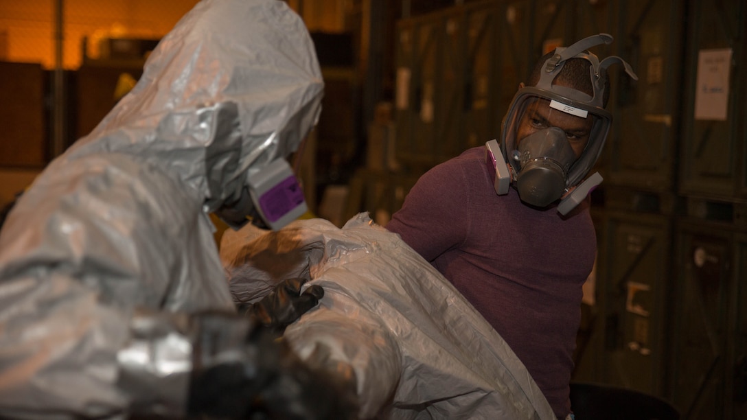 A Marine from Marine Wing Support Squadron 171 assists Sgt. Deedmund Nettles, left, food service specialist with MWSS-171, in removing his personal protective equipment during Hazardous Waste Operations and Emergency Response training at Marine Corps Air Station Iwakuni, Japan, Dec. 18, 2015. The course covered topics such as the hazards associated with working around chemicals, how to locate information on different chemicals, and the four aspects of planning and organizing a hazardous waste site, which are organizational structure, work plan, safety meetings and inspections. This training provided Marines with the proper knowledge to identify contain and clean up hazardous materials. 