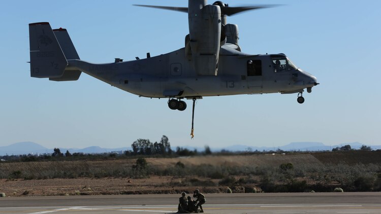 Marines with Combat Logistics Battalion 5 prepare to attach a simulated cargo of 1,400 pounds to an MV-22B Osprey with Marine Medium Tiltrotor Squadron 363 aboard Marine Corps Air Station Miramar, Calif., Dec. 16, 2015. Daytime external lift training prepares the Marines with VMM-363 to attach cargo to the aircraft which helps qualify more air crew in the mission-essential task of rapid insertion and extraction for the squadron. 