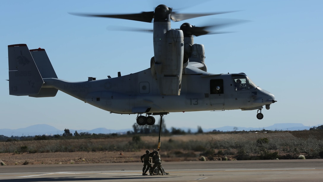 Marines with Combat Logistics Battalion 5 attach a simulated cargo of 1,400 pounds to an MV-22B Osprey with Marine Medium Tiltrotor Squadron 363 at Marine Corps Air Station Miramar, California, Dec. 16, 2015. Daytime external lift training prepares the Marines with VMM-363 to attach cargo to the aircraft which helps qualify more air crew in the mission-essential task of rapid insertion and extraction for the squadron. 