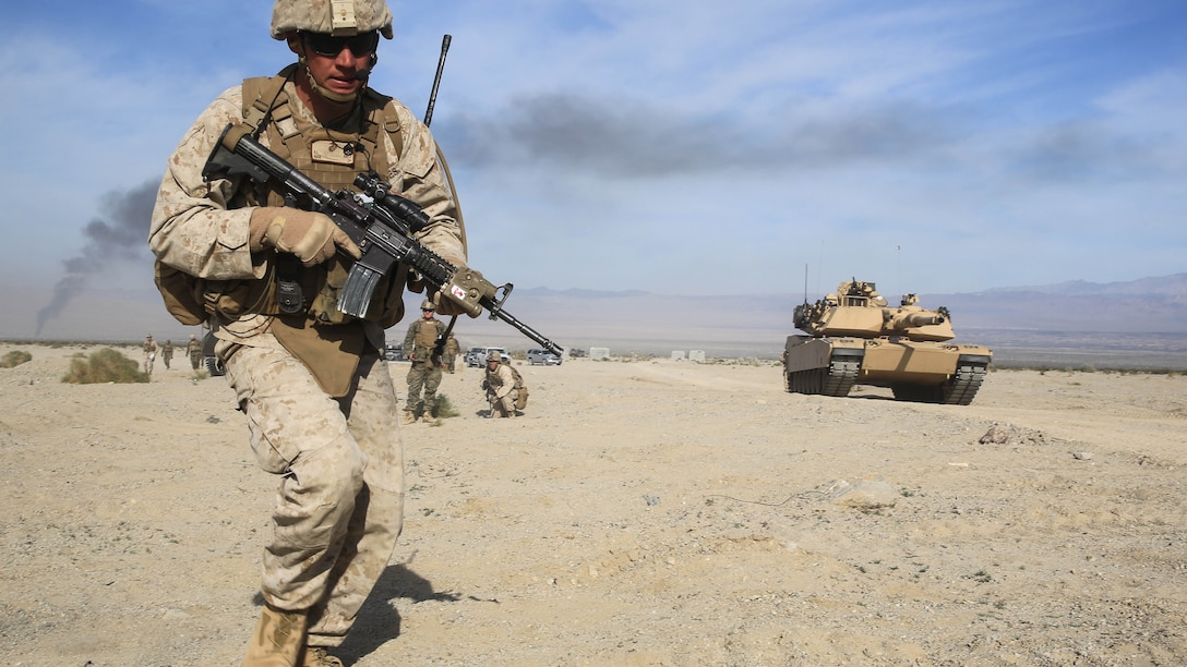 Staff Sgt. Anthony L. Abitz charges toward a mock combat town during the mechanized assault portion of a Marine Corps Combat Readiness Evaluation at Marine Corps Air Ground Combat Center Twentynine Palms, Calif., Dec. 10, 2015. The purpose of a MCCRE is to evaluate Marines’ collective performance in requisite specific mission requirements that will prepare them for their upcoming deployment rotations. Staff Sgt. Abitz is a machine gunner with 2nd Battalion, 7th Marine Regiment, 1st Marine Division. 
