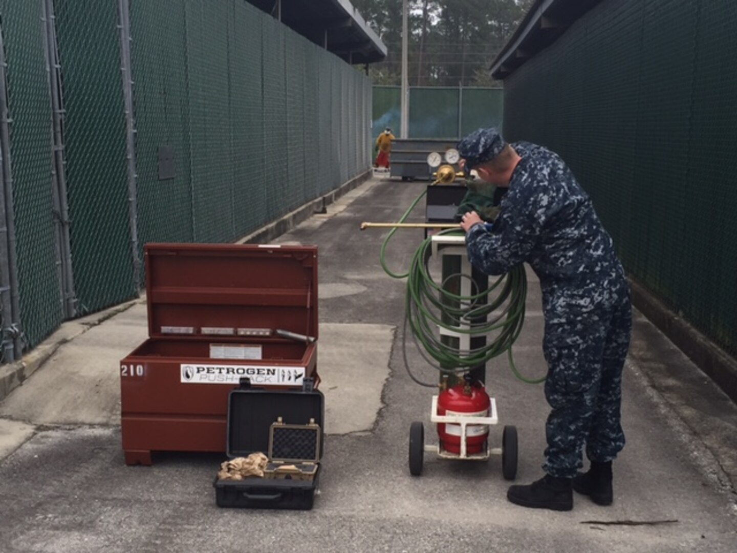 A Disposition Services Unit Six sailor inspects cutting systems for safety.