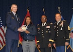 DLA director Air Force Lt. Gen. Andy Busch, left, presents Kareneshia Stubblefield, distribution process worker at Distribution Norfolk, Va., with the Top 10 Employee award at the 48th annual employee recognition ceremony Dec. 10. Distribution’s commander Army Brig. Gen. Richard Dix, second from right, and DLA’s Senior Enlisted Leader Army Command Sgt. Maj. Charles Tobin, right, were also on-hand to present the award.