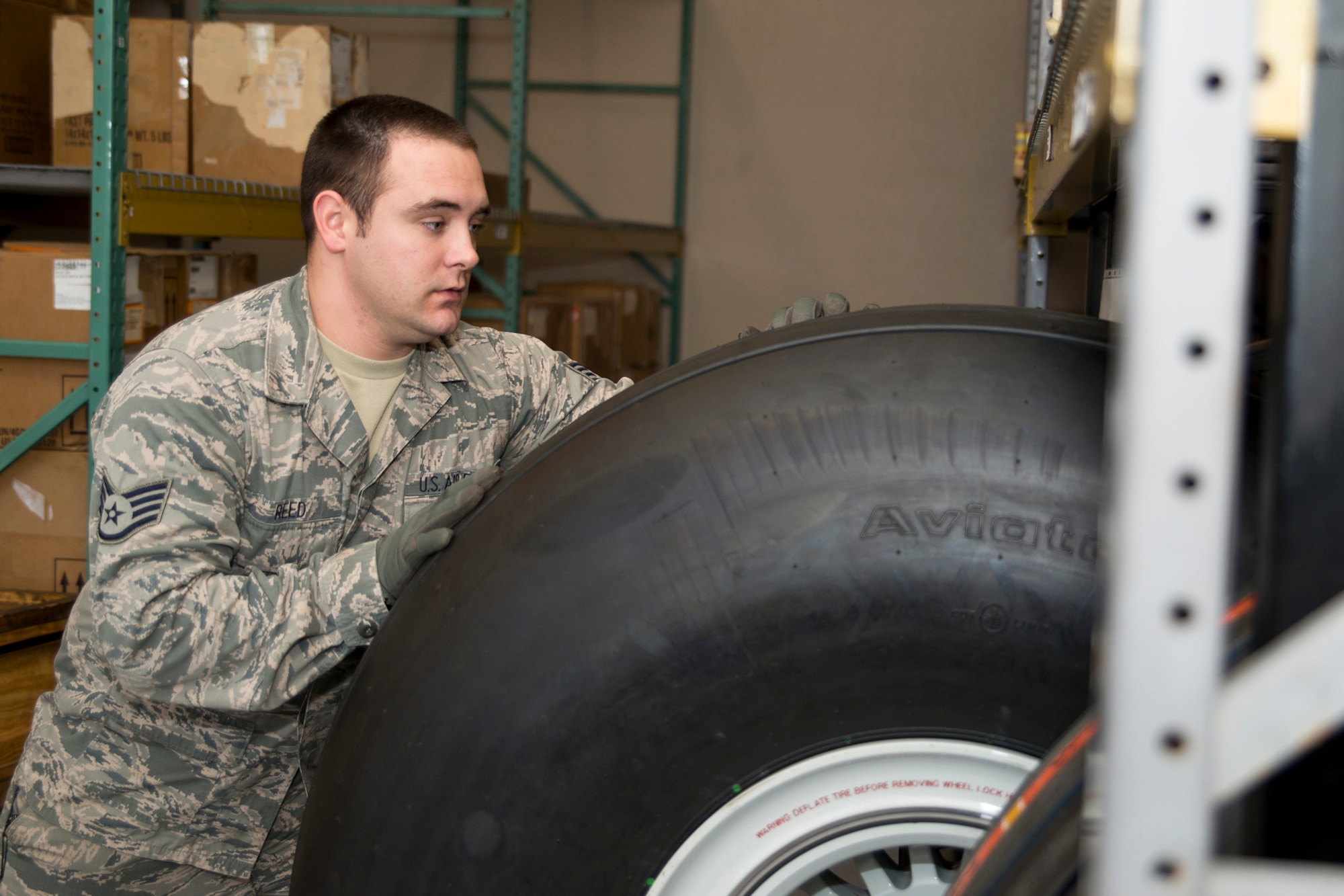 U.S. Air Force Staff Sgt. Michael Reed, an aircraft parts store craftsman assigned to the 913th Force Support Squadron/Supply, loads a C-130 main tire into a tire rack at Little Rock, Air Force Base, Ark., Dec. 21, 2015. The aircraft parts store is manned 24 hours a day with Airmen from the 19th Logistics Readiness Squadron and 913th FSS, and supplies parts for C-130 aircraft maintenance at Little Rock and for mission capable aircraft around the world.  (U.S. Air Force photo by Master Sgt. Jeff Walston)