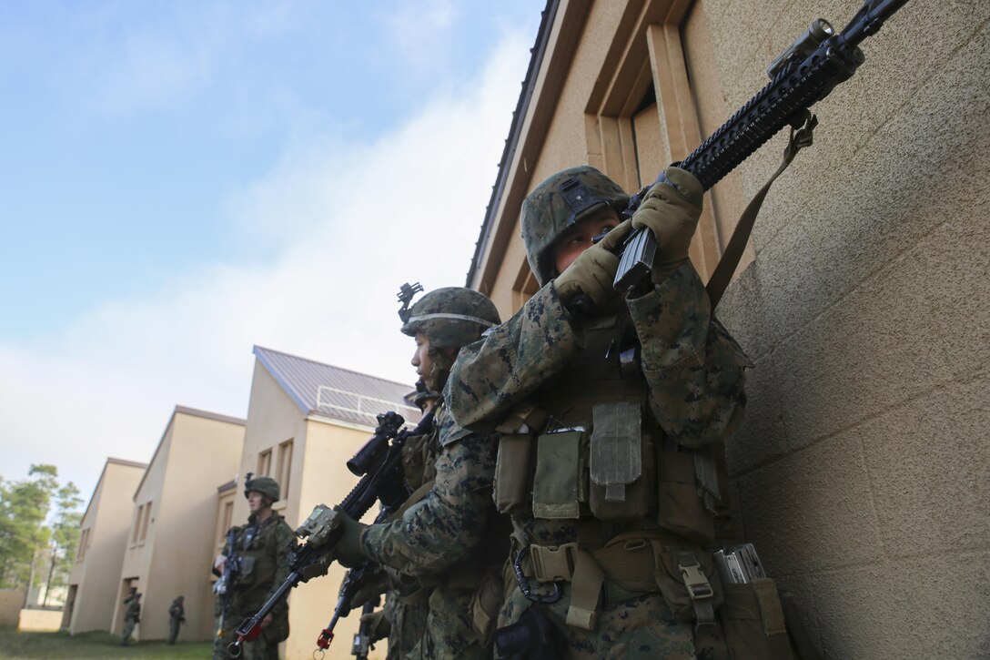 Marines with 3rd Battalion, 6th Marine Regiment, engage an opposing force during a limited objective experiment at Camp Lejeune, N.C., Dec. 10, 2015. The Marine Corps Warfighting Laboratory worked with 3rd. Bn, 6th Marines, and 1st Battalion, 10th Marine Regiment, to test artillery and infantry integration tactics. During the experiment, the company landing team attacked from near the Onslow Beach landing site towards the objective of the Military Operation in Urban Terrain training center. (U.S. Marine Corps photo by Cpl. Michael Dye/Released)