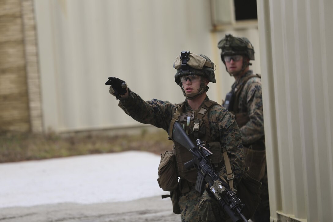 Lance Cpl. Trevor Lancaster, a rifleman with 3rd Battalion, 6th Marine Regiment, gives direction during a limited objective experiment at Camp Lejeune, N.C., Dec. 8, 2015. The Marine Corps Warfighting Laboratory worked with 3rd Bn., 6th Marines, and 1st Battalion, 10th Marine Regiment, to test artillery and infantry integration tactics. During the experiment, the company landing team attacked from near the Onslow Beach landing site towards the objective of the Military Operation in Urban Terrain training center. (U.S. Marine Corps photo by Cpl. Michael Dye/Released)