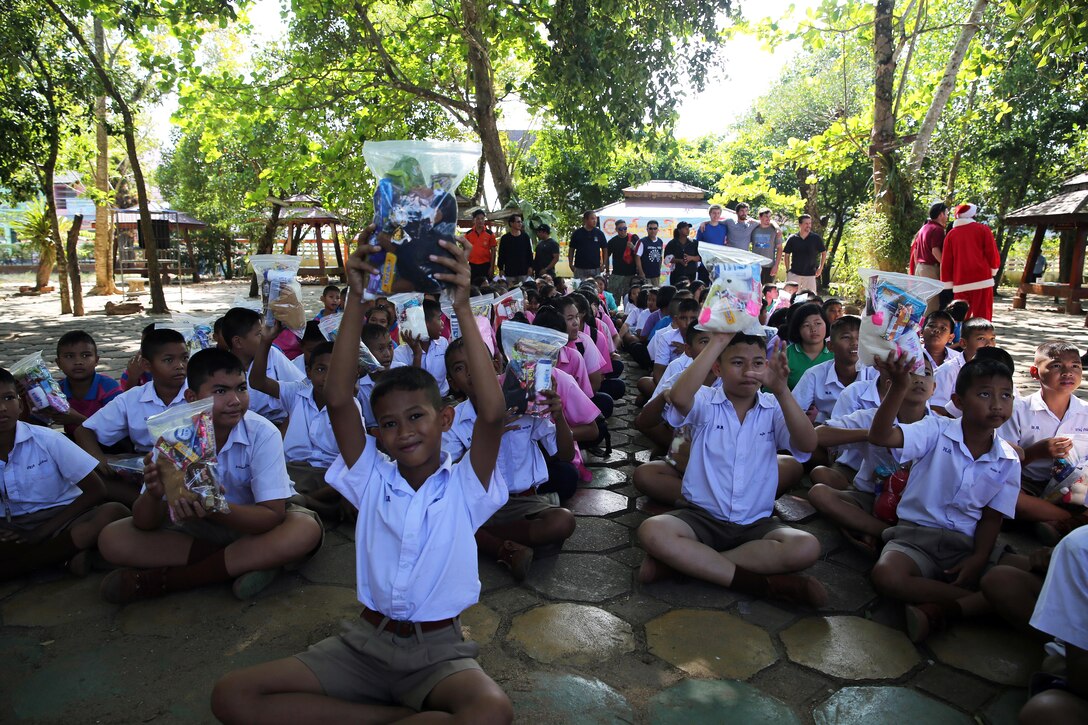 Elementary school students receive donated books during a community outreach event in Chanthaburi, Thailand, Dec. 21, 2015. U.S. Navy photo by Grady T. Fontana