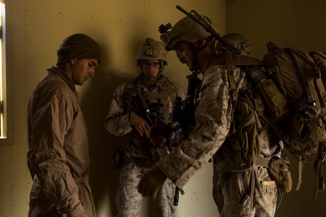 U.S. Marine Corps Cpl. Justin Jones, a squad leader with Fox Company, 2nd Battalion, 7th Marine Regiment, 1st Marine Division speaks to an enemy role player in a tactical recovery aircraft personnel exercise as a part of Steel Knight 16 at Fort Hunter Liggett, Calif., Dec. 11, 2015. Steel Knight is an annual field training exercise that enables 1st Marine Division to test and refine its command and control capabilities by acting as the headquarters element for a forward-deployed Marine Expeditionary Force. (U.S. Marine Corps Combat Camera photograph by ( Lance Cpl. Roderick L. Jacquote)/RELEASED)