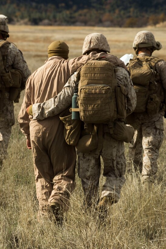 U.S. Navy Hospitalman Michael Fleeman, a corpsmen with Fox Company, 2nd Battalion, 7th Marine Regiment, 1st Marine Division aids a downed pilot during a tactical recovery aircraft personnel exercise as a part of Steel Knight 16 at Fort Hunter Liggett, Calif., Dec. 11, 2015. Steel Knight is an annual field training exercise that enables 1st Marine Division to test and refine its command and control capabilities by acting as the headquarters element for a forward-deployed Marine Expeditionary Force. (U.S. Marine Corps Combat Camera photograph by ( Lance Cpl. Roderick L. Jacquote)/RELEASED)