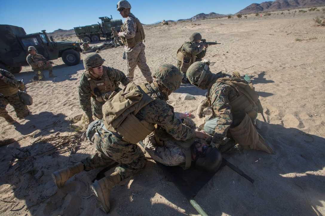U.S. Marines and Sailors with Headquarters Company, 5th Marine Regiment, 1st Marine Division aid a simulated casualty as a part of a tactical recovery aircraft personnel mission in support of Steel Knight 16 at Marine Corps Air-Ground Combat Center, Twentynine Palms, Calif., Dec. 12, 2015. Steel Knight is an annual field training exercise that enables 1st Marine Division to test and refine its command and control capabilities by acting as the headquarters element for a forward-deployed Marine Expeditionary Force. (U.S. Marine Corps Combat Camera photograph by ( Lance Cpl. Roderick L. Jacquote)/RELEASED)