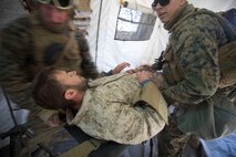 U.S. Marines and Sailors with Headquarters Company, 5th Marine Regiment, 1st Marine Division aid a simulated casualty as a part of a tactical recovery aircraft personnel mission in support of Steel Knight 2016 at Marine Corps Air-Ground Combat Center, Twentynine Palms, Calif., Dec. 12, 2015. Steel Knight is an annual field training exercise that enables 1st Marine Division to test and refine its command and control capabilities by acting as the headquarters element for a forward-deployed Marine Expeditionary Force. (U.S. Marine Corps Combat Camera photograph by ( Lance Cpl. Roderick L. Jacquote)/RELEASED)