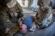 U.S. Marines and Sailors with Headquarters Company, 5th Marine Regiment, 1st Marine Division aid a simulated casualty as a part of a tactical recovery aircraft personnel mission in support of Steel Knight 2016 at Marine Corps Air-Ground Combat Center, Twentynine Palms, Calif., Dec. 12, 2015. Steel Knight is an annual field training exercise that enables 1st Marine Division to test and refine its command and control capabilities by acting as the headquarters element for a forward-deployed Marine Expeditionary Force. (U.S. Marine Corps Combat Camera photograph by ( Lance Cpl. Roderick L. Jacquote)/RELEASED)