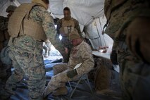 U.S. Marines and Sailors with Headquarters Company, 5th Marine Regiment, 1st Marine Division aid a simulated casualty as a part of a tactical recovery aircraft personnel mission in support of Steel Knight 2016 at Marine Corps Air-Ground Combat Center, Twentynine Palms, Calif., Dec. 12, 2015. Steel Knight is an annual field training exercise that enables 1st Marine Division to test and refine its command and control capabilities by acting as the headquarters element for a forward-deployed Marine Expeditionary Force. (U.S. Marine Corps Combat Camera photograph by ( Lance Cpl. Roderick L. Jacquote)/RELEASED)