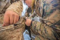 U.S. Navy Lt. Christopher Mullin, 5th Marine Regiment surgeon, applies a tourniquet on a simulated casualty as a part of a tactical recovery aircraft personnel mission in support of Steel Knight 2016 at Marine Corps Air-Ground Combat Center, Twentynine Palms, Calif., Dec. 12, 2015. Steel Knight is an annual field training exercise that enables 1st Marine Division to test and refine its command and control capabilities by acting as the headquarters element for a forward-deployed Marine Expeditionary Force. (U.S. Marine Corps Combat Camera photograph by ( Lance Cpl. Roderick L. Jacquote)/RELEASED)