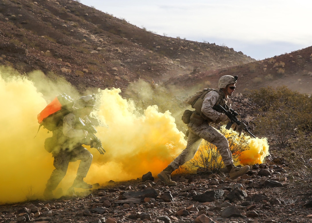 Marines run through the obstruction of smoke during the live-fire assault portion of a combat readiness evaluation on Marine Corps Air Ground Combat Center Twentynine Palms, Calif., Dec. 6, 2015. The evaluation helps prepare them for their upcoming deployment rotation. The Marines are assigned to the 1st Marine Division's 2nd Battalion, 7th Marine Regiment. U.S. Marine Corps photo by Lance Cpl. Devan K. Gowans