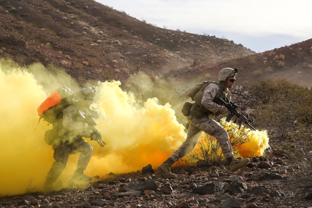 Marines run through smoke during a live-fire assault portion of a combat readiness evaluation on Marine Corps Air Ground Combat Center Twentynine Palms, Calif., Dec. 6, 2015. The evaluate prepares them for their upcoming deployment rotation. The Marines are assigned to the 1st Marine Division's 2nd Battalion, 7th Marine Regiment. Marine Corps photo by Lance Cpl. Devan K. Gowans