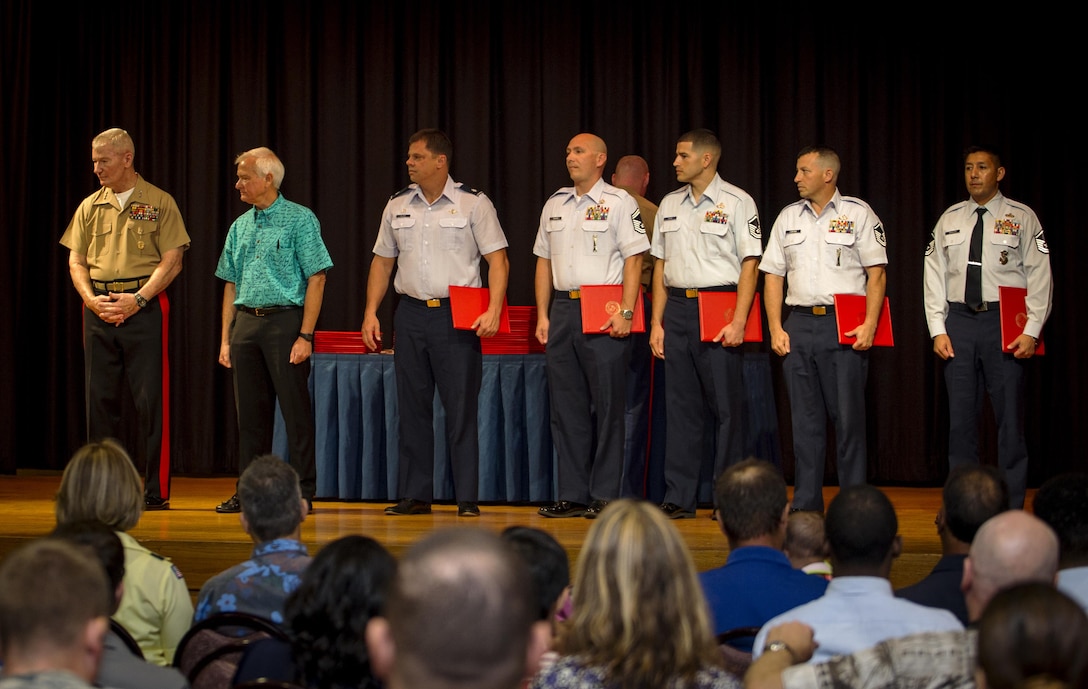 U.S. Marine Corps Lt. Gen. John A. Toolan (left), U.S. Marine Corps Forces, Pacific commander, and Mayor Kirk Caldwell (second – left) of the city and county of Honolulu recognized the Airmen that selflessly helped the Marines and Sailor during the 15th Marine Expeditionary Unit MV-22 Osprey tilt-rotor aircraft mishap, May 17, 2015, during the First Responder Recognition Ceremony at the Neal S. Blaisdell Center, in Honolulu, Dec. 18, 2015.  Military and civilian personnel that selflessly assisted during the rescue and treatment of the Marines and Sailor were honored by the MARFORPAC commander. (Left to right) The Airmen recognized were Lt. Col. Mike Blake, 154th Operations Support Squadron; SMSgt Sam Sharpe and Master Sgts. Anthony Gauna, Michael Ledford and Juan Guzman, Headquarters Pacific Air Forces logistics directorate. (U.S. Marine Corps photo by Lance Cpl. Jonathan E. Lopez Cruet/Released)