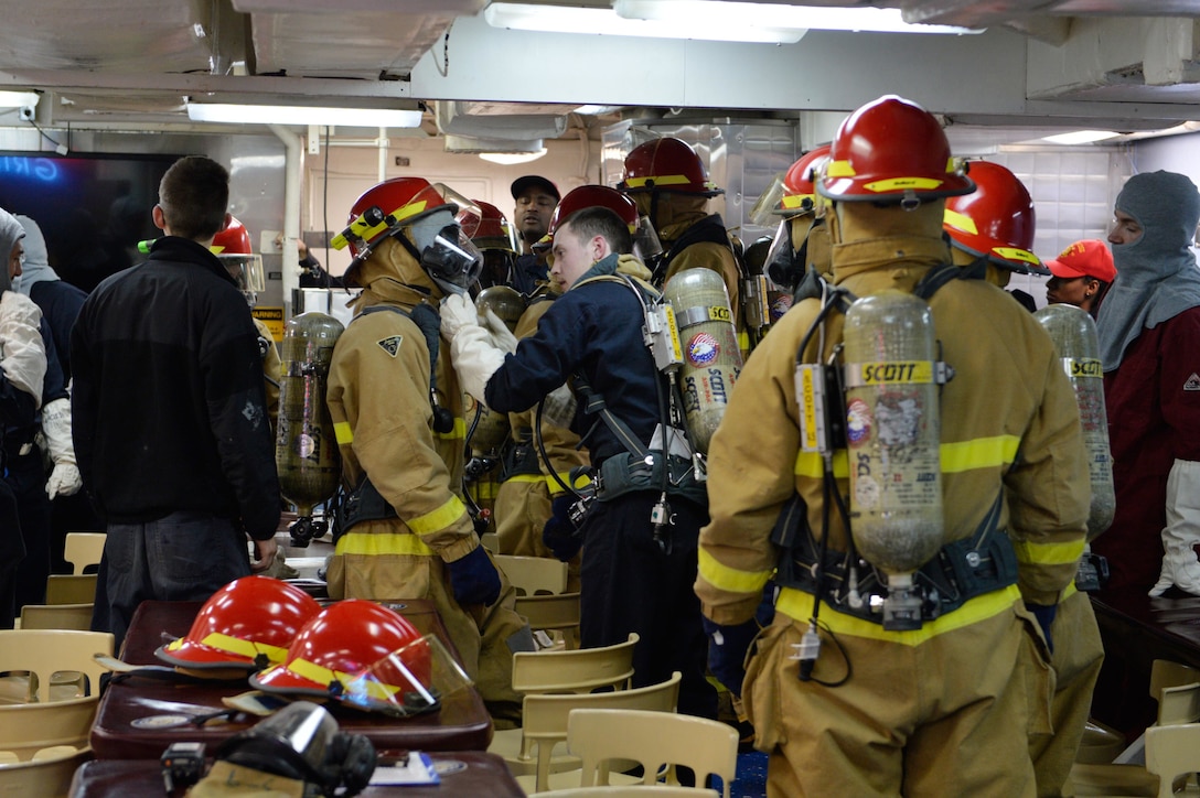 U.S. sailors put on firefighting gear and prepare to participate in a fire drill aboard the USS Ross in the Black Sea, Dec. 10, 2015. U.S. Navy photo by Petty Officer 2nd Class Justin Stumberg