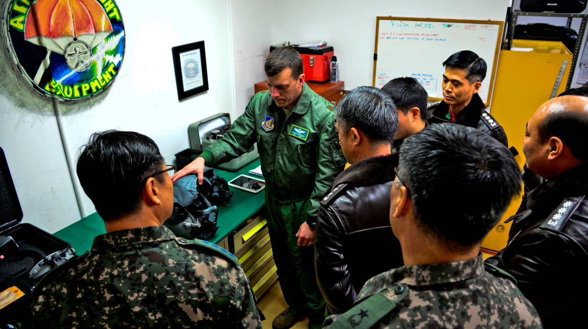 Maj. Craig Morash (second from left), 25th Fighter Squadron director of operations, explains the functions of an A-10 Thunderbolt II flight helmet during an immersion tour for Republic of Korea air force Lt. Gen. Lee, Wang Keun, Air Force Operations Command commander, at Osan Air Base, ROK, Dec. 17, 2015. Senior leaders from the ROK AFOC toured the base to learn about the various aircraft, mission and capabilities the 51st Fighter Wing supports on the peninsula. (U.S. Air Force photo/Tech. Sgt. Travis Edwards)
